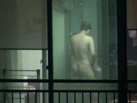 Чувак подсматривает за одной телкой в окне, которая голенькой стоит у вентилятора